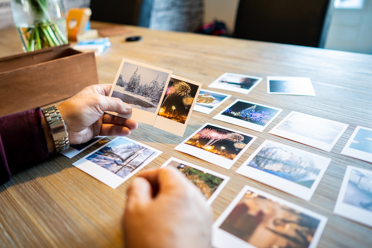 Profesionál kontrolujúci fotografie pred tlačou na pracovnom stole